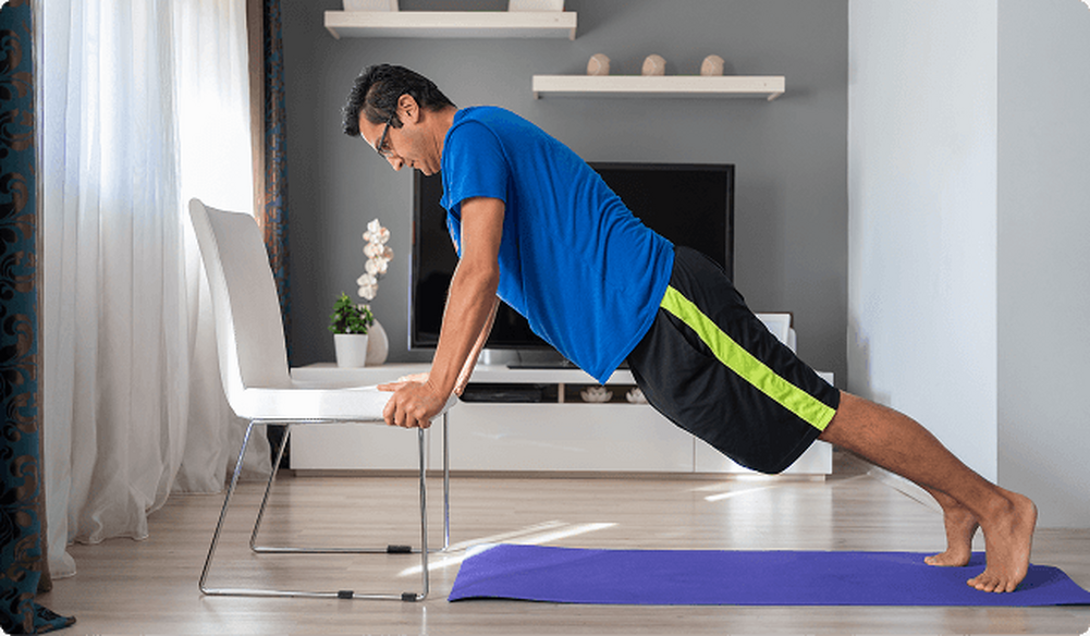 Man doing push ups off a chair